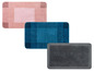Drei Badematten in rosa, blau und grau.