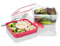 Eine rosa Lunchbox mit Salat, Mozzarella und Dressing.