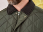 Grüne Steppjacke mit Cordkragen.