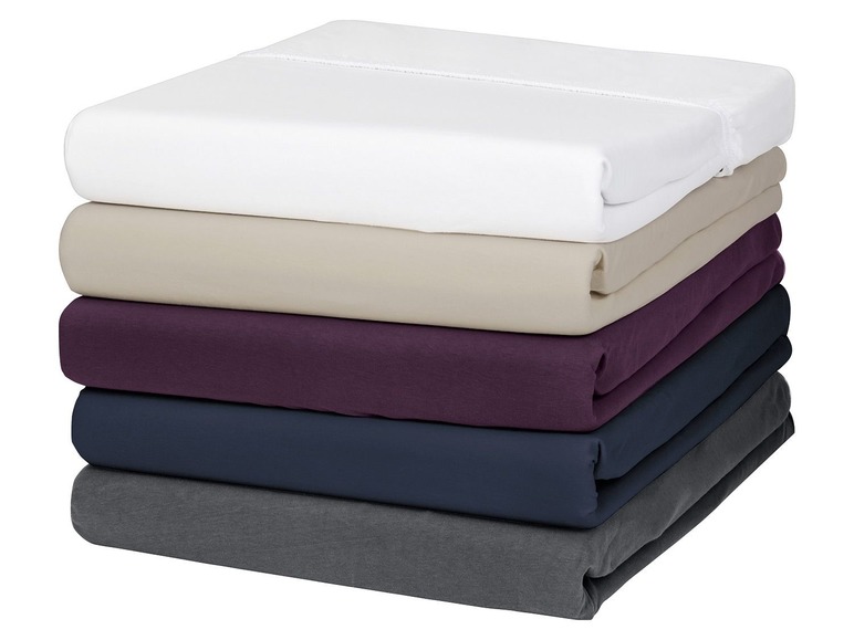 Ein Stapel Bettwäsche in verschiedenen Farben, darunter Weiß, Beige, Lila und Dunkelblau.