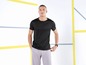 Mann in schwarzem T-Shirt und grauen Jogginghosen.