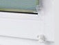 Ein weißes Fenster mit einem grünen Rollladen.
