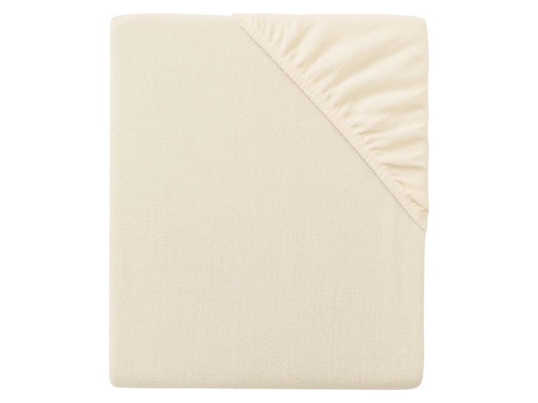 Ein beiges Baumwoll-Spannbettlaken für ein Babybett.