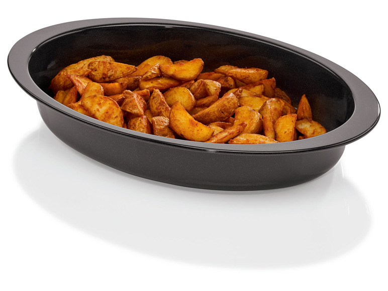 Gebratene Kartoffelspalten in einer schwarzen Auflaufform.