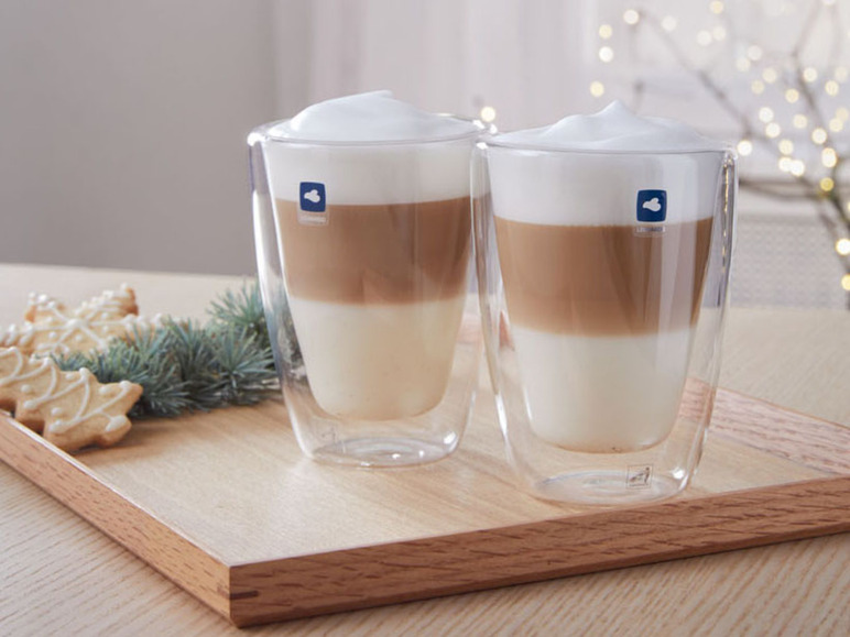 Zwei Latte Macchiato in doppelwandigen Bodum Gläsern auf einem Holztablett.