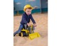 Ein Kind spielt mit einem gelben Spielzeugbagger im Sand.
