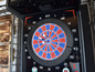 Ein Dartboard mit Pfeilen in einem Dart-Automaten.
