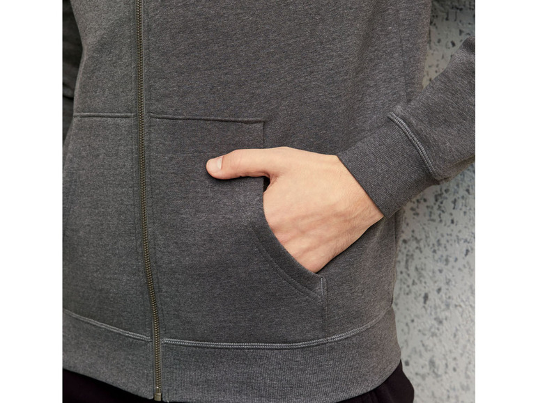 Ein grauer Reißverschluss-Pullover mit einer Tasche.