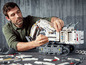 Ein Mann baut ein LEGO Liebherr R 9800-Bagger.