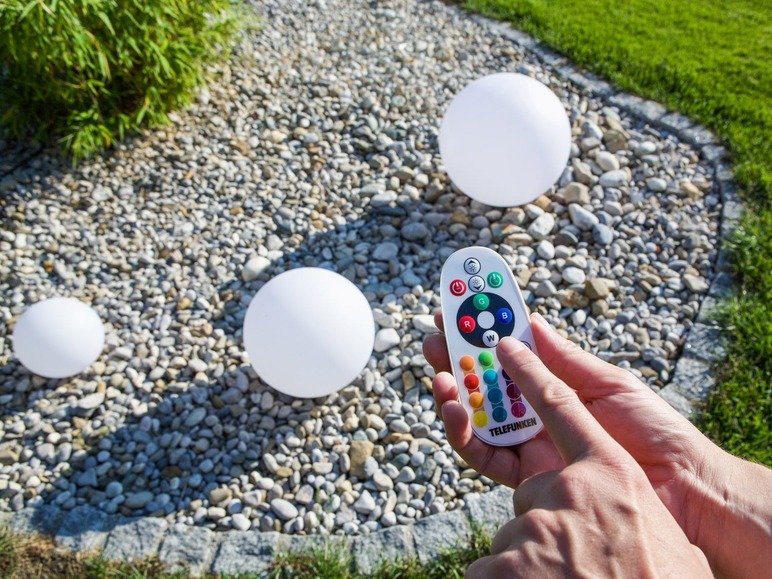 Drei weiße kugelförmige Lampen, die mit einer Telefunken Fernbedienung gesteuert werden.
