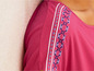 Ein rosafarbenes Shirt mit einem bestickten Ärmel.