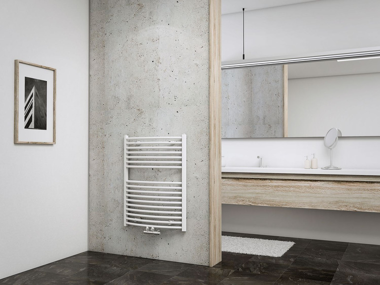 Ein weißer Handtuchheizkörper in einem modernen Badezimmer mit einer Betonwand.