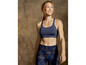 Frau in einem Sport-BH und Leggings mit Camouflage-Muster.