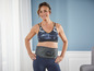 Eine Frau mit einem Medisana-Gürtel zur Bauchmuskelkräftigung.