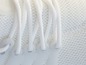 Weiße Sneaker mit Schnürsenkeln und Mesh-Material.