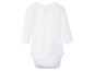 Ein weißer Baby-Body mit Sternenmuster.