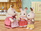 Drei Calico Critters Kaninchenfiguren in einer Küchenumgebung.