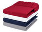 Ein Stapel aus vier Spannbettlaken in Rot, Weiß, Blau und Grau.