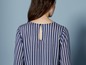 Frau in einer blau-weißen gestreiften Bluse mit langen Ärmeln.