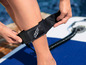 Nahaufnahme eines schwarzen GHF-Bandes um einen Knöchel auf einem Paddleboard.