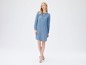 Eine Frau trägt ein blaues Jeanskleid.