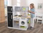 Ein Kind spielt mit einer Spielzeugküche mit Backofen, Waschmaschine und Kühlschrank.