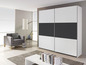 Ein weißer Schiebetürenschrank mit schwarzem Panel in einem modernen Interieur.
