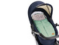 Ein blauer Kinderwagen mit einem grünen Schlafsack der Marke 'Fillikid'.