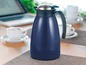 Eine blaue Thermoskanne auf einem Tisch mit Kaffeetassen.