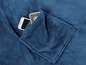 Eine blaue Fleece-Decke mit einer Tasche, in der sich ein Smartphone und eine Fernbedienung befinden.
