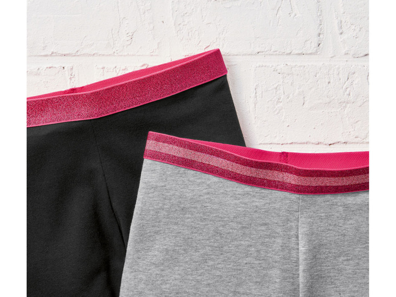Zwei Leggings mit rosa Bändern.