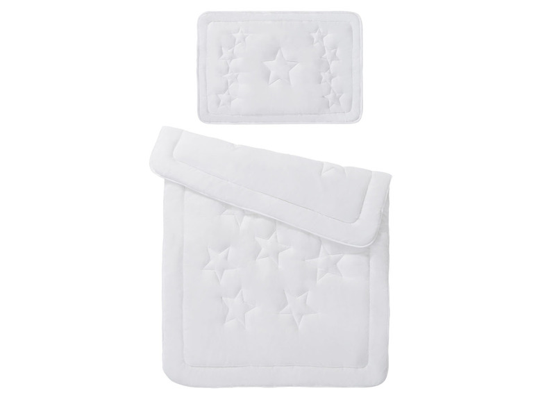 Eine weiße Bettdecke und ein Kissen mit Sternenmuster.