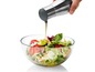 Ein Salat wird mit Öl aus einer Sprühflasche beträufelt.