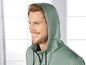 Mann trägt einen grünen Hoodie mit Reißverschluss.