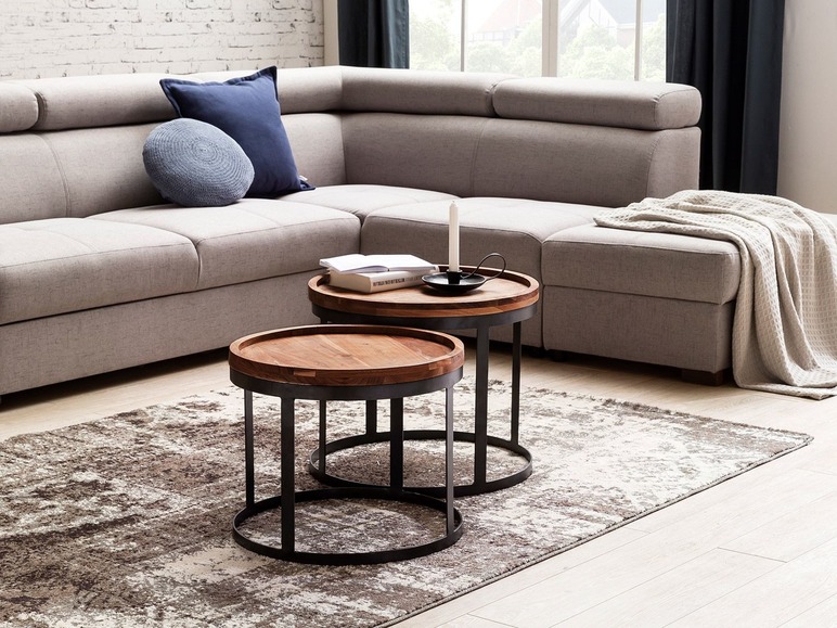 Zwei runde Couchtische aus Holz mit Metallgestell in einem modernen Interieur.