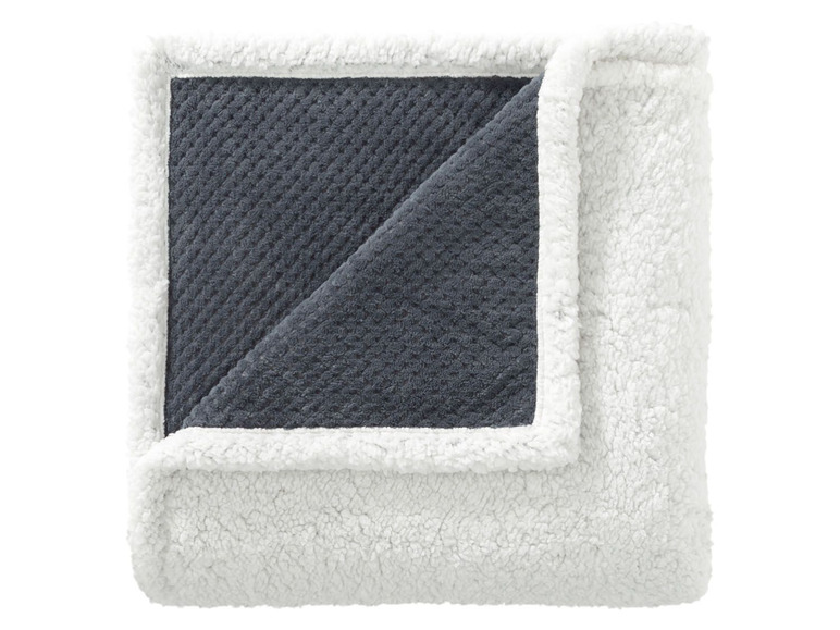 Eine graue und weiße Decke mit weichem Fleecefutter.