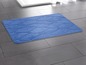 Eine blaue Badezimmermatte mit einem Wellenmuster