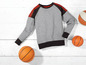 Ein graues Sweatshirt mit Basketbällen.