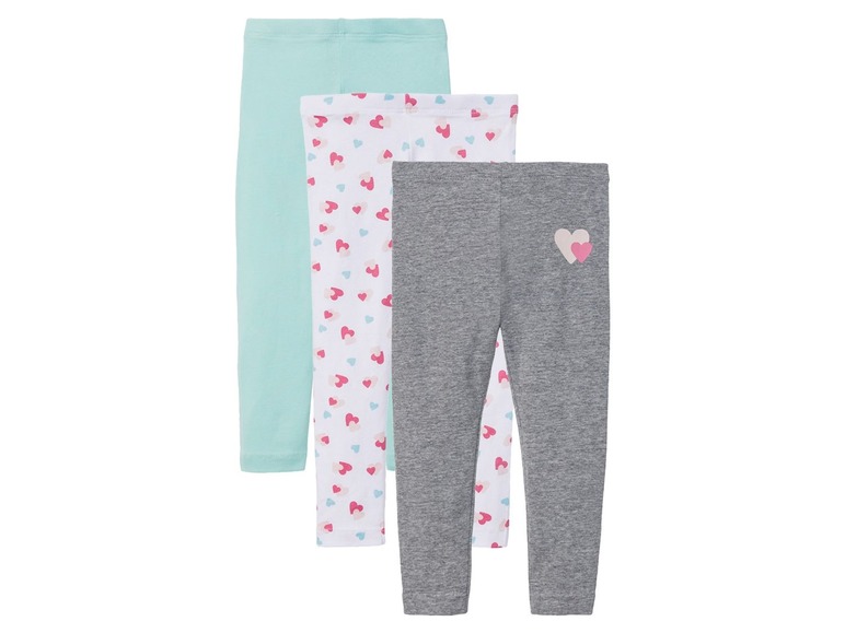 Drei Leggings für Mädchen, eine grau, eine weiß mit rosafarbenen Herzen und eine hellblau.