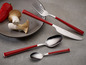 Ein Messer, eine Gabel und Löffel mit roten Griffen von Echtwerk.