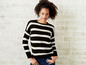 Eine Frau trägt einen schwarz-weiß gestreiften Pullover.