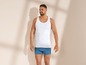 Mann in weißem Tanktop und blauen Boxershorts.