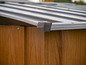 Ein Holzschuppen mit einem grauen Metalldach.