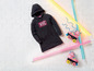 Ein schwarzer Hoodie mit 'NYC' und rosa Rollschuhe mit Neonlicht.
