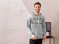 Ein Mann trägt einen grauen Hoodie mit dem Aufdruck 'Turn Up'.