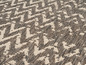 Ein Teppich mit einem Zickzackmuster in Grau und Weiß.