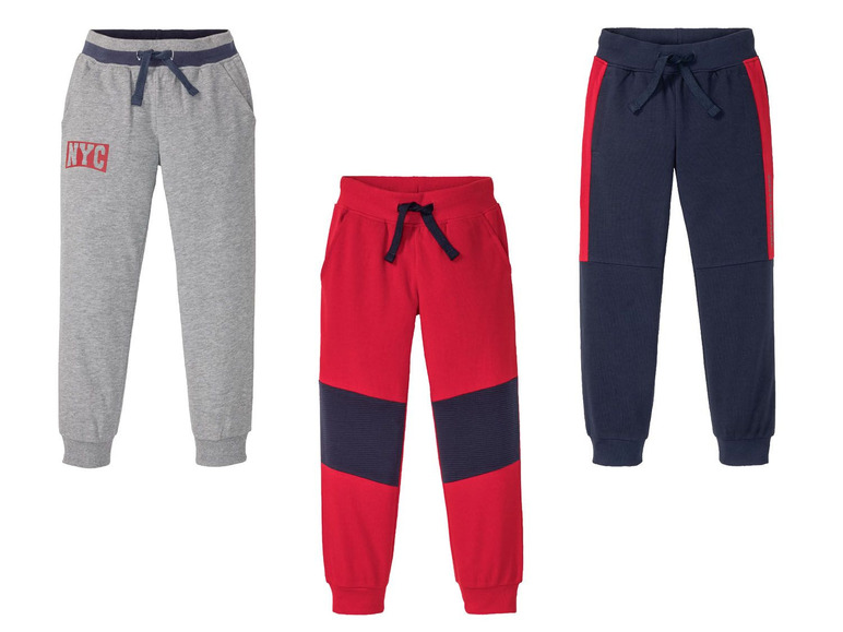 Drei Jogginghosen für Jungen: Grau, Rot mit blauen Details und Dunkelblau mit roten Details.