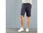 Mann in blauen Chino-Shorts und weißen Sneakern.