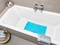 Eine Badewanne mit einer blauen Badematte und einem Handtuch.