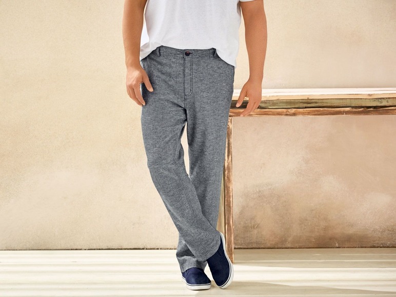 Mann trägt graue Hose und weißes T-Shirt.